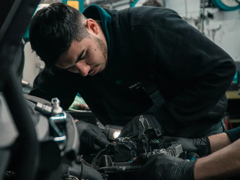 Mekaniker skrur på motoren i en bil